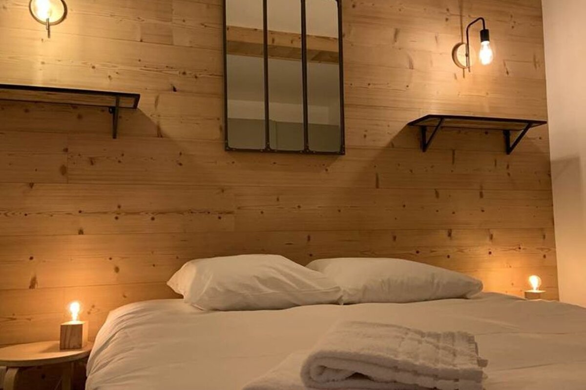 A bedroom with a bed and a mirror on the wall