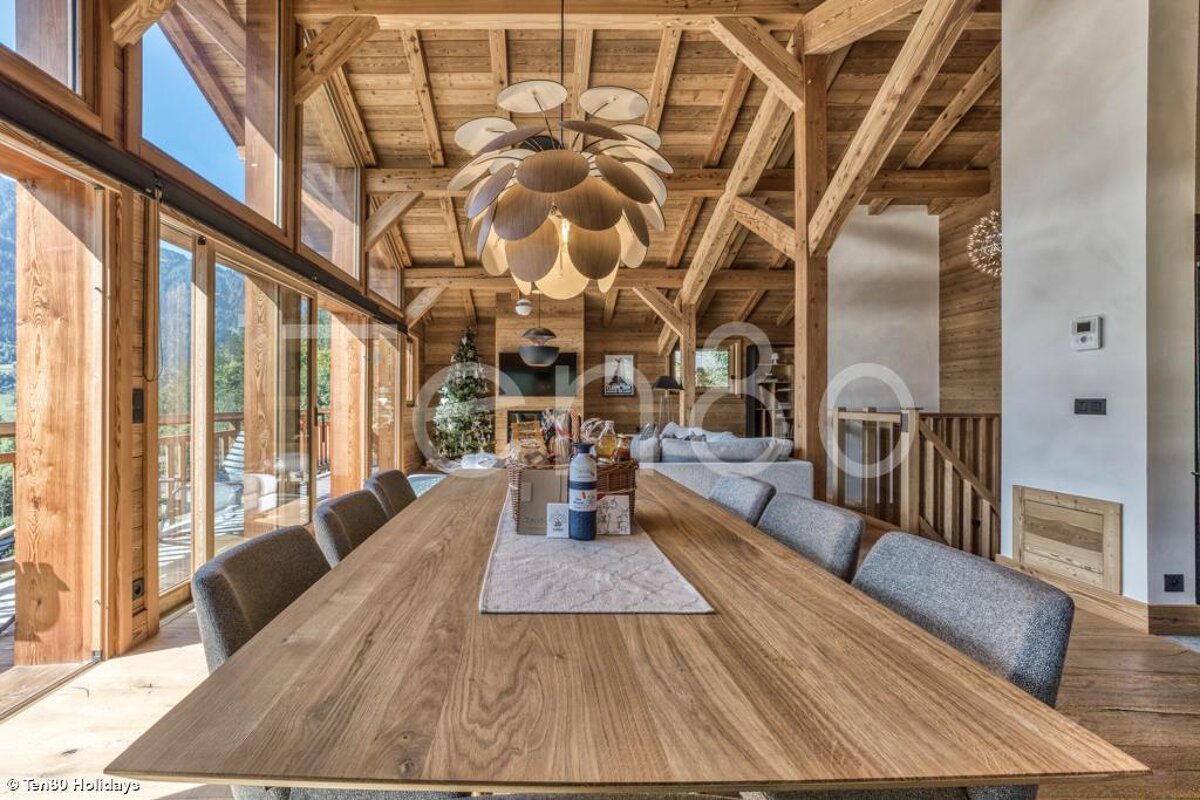 A large wooden table with a chandelier hanging from the ceiling