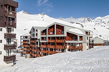 A snow covered building with a mountain in the background
