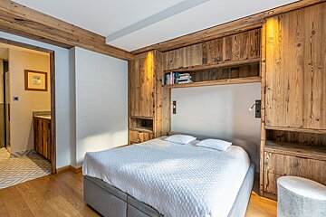 A bedroom with a large bed and wooden cabinets