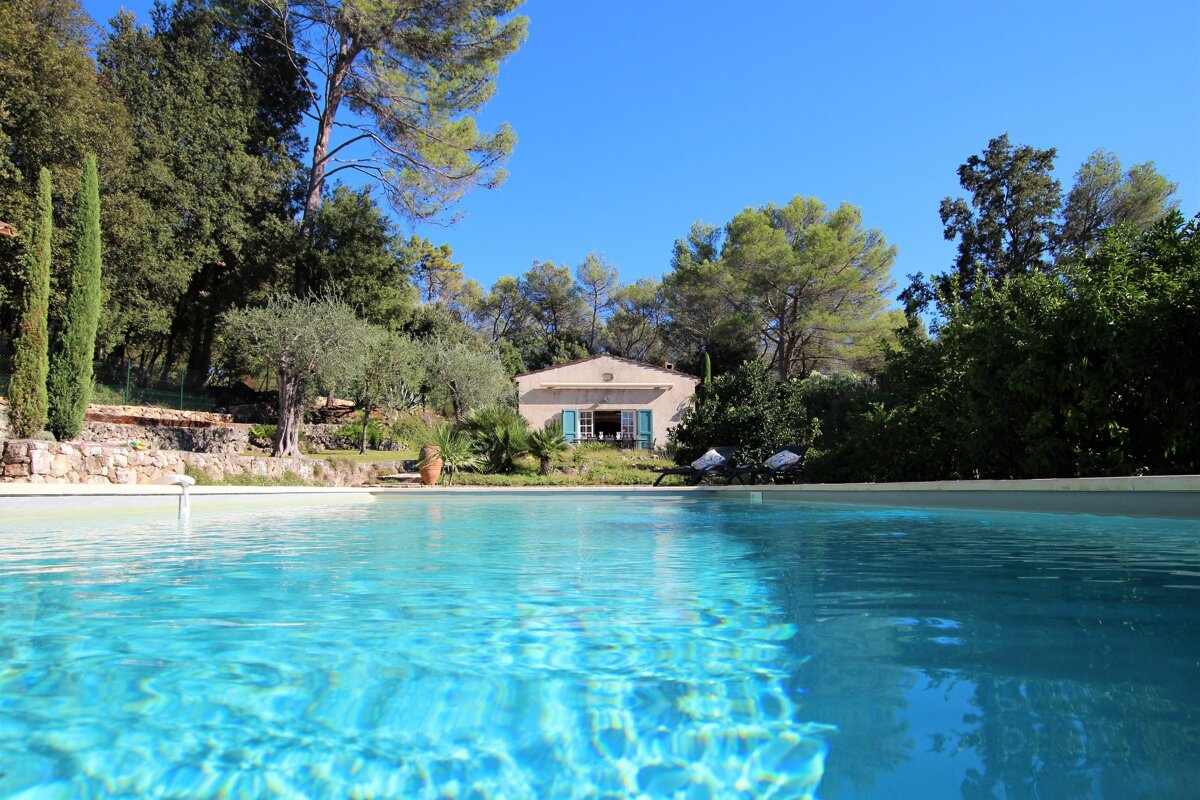 A swimming pool with a house in the background