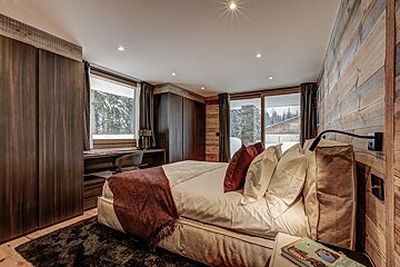 A bedroom with a large bed and a book on the nightstand