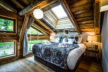 A bedroom with a king size bed and a skylight