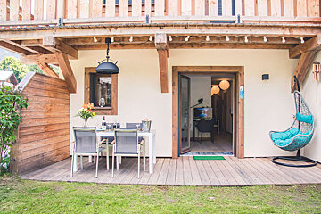 A patio with a table and chairs and a hanging chair