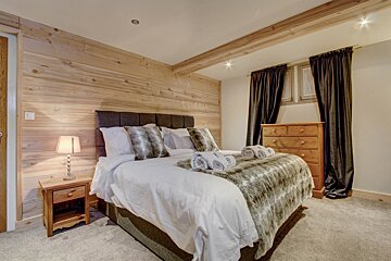 A bedroom with a king size bed and a nightstand