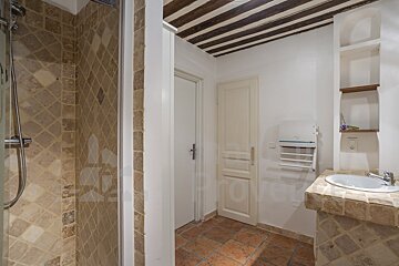 A bathroom with a sink and a shower with a sign that says ' a ' on it