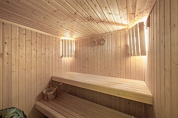 A wooden sauna with a bucket on the bench
