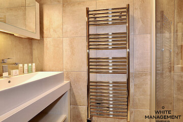 A bathroom with a towel rack and a sign that says rental designer