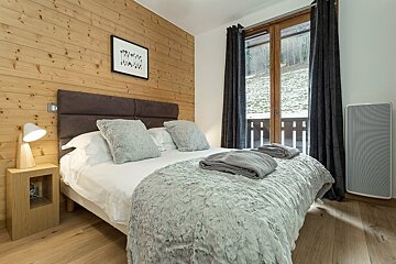A bedroom with a bed and a picture on the wall that says