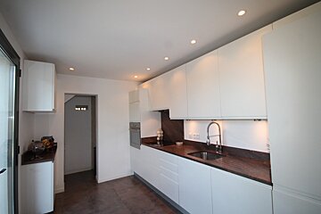 A kitchen with white cabinets and a sink