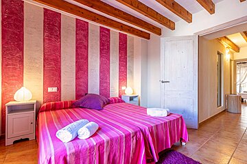 A bedroom with pink and white stripes on the wall