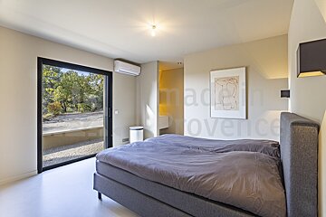 A bedroom with a large bed and a picture on the wall that says made in provence