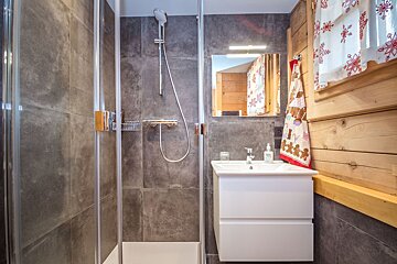 A bathroom with a walk in shower and a sink