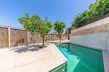 A swimming pool surrounded by trees and a fence