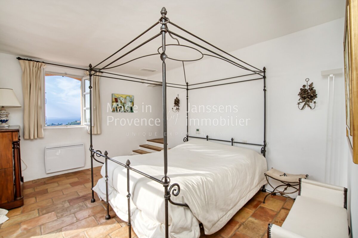 A bedroom with a four poster bed and a sign that says made in provence