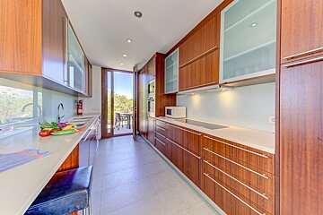 A kitchen with wooden cabinets and white counter tops