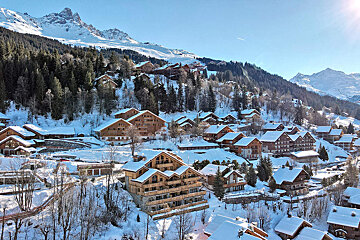 A snow covered village with mountains in the background