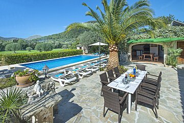 A table and chairs in front of a swimming pool