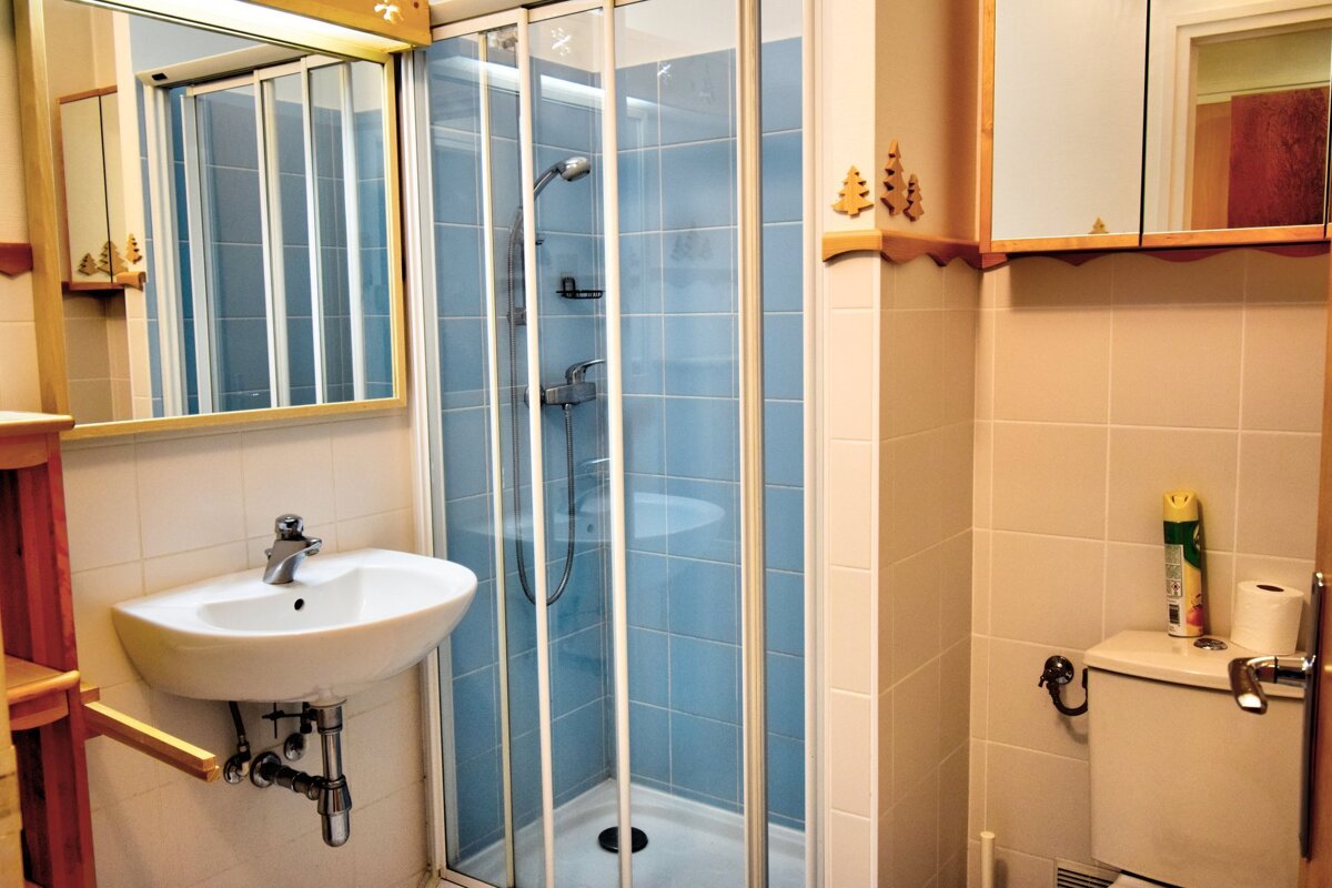 A bathroom with a toilet a sink and a shower stall