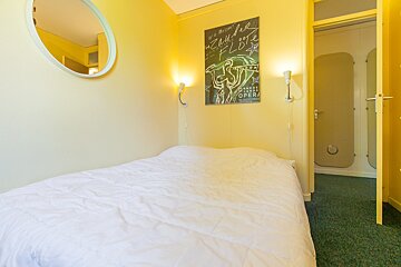 A bedroom with a bed and a poster on the wall that says opera