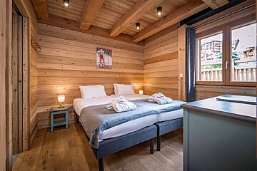A bedroom with two beds and a poster on the wall that says ski