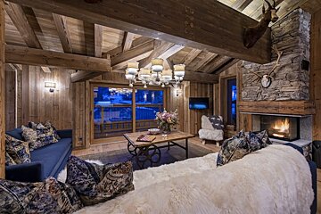 A living room with a blue couch and a fireplace