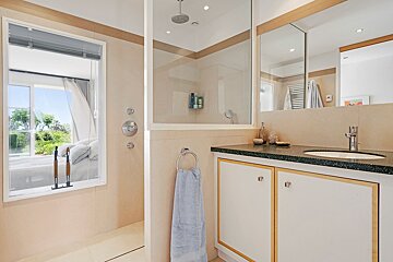 A bathroom with a walk in shower and a sink