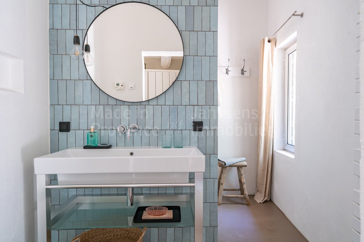 A bathroom with a sink and a mirror with the words made in on the wall