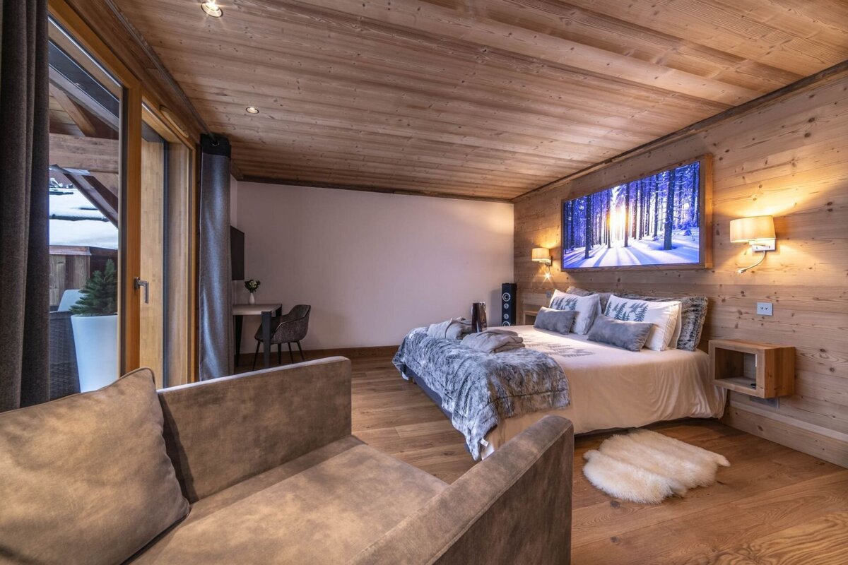 A bedroom with a large bed and a chair