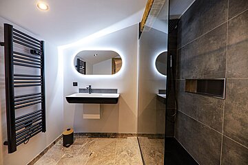 A bathroom with a sink a mirror and a towel rack