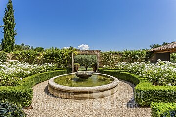 A fountain in a garden with a sign that says knight frank