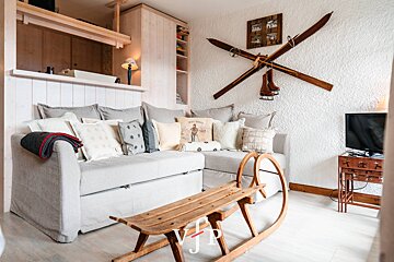 A living room with a couch and skis on the wall