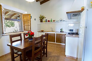 A kitchen with a table and chairs and a microwave