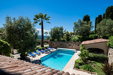 A large swimming pool surrounded by chairs and palm trees