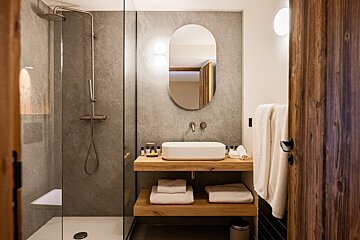 A bathroom with a sink a mirror and a walk in shower