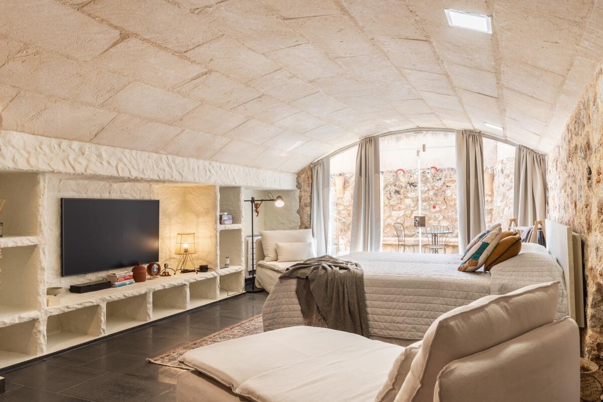 A bedroom with two beds and a flat screen tv