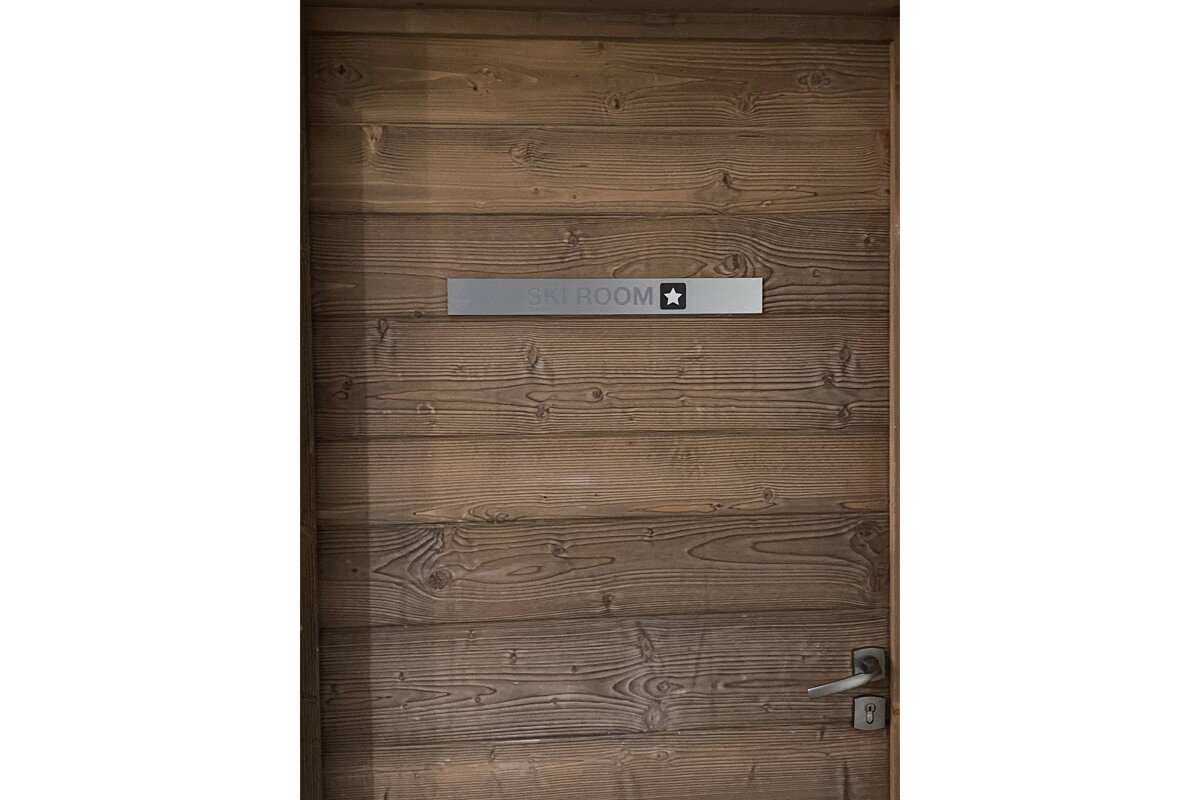 A wooden door with a sign that says ski room