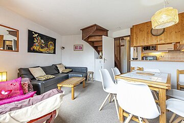 A living room with a couch a table and chairs
