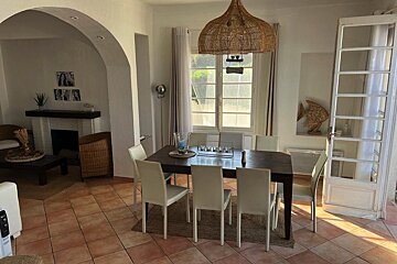 A dining room with a table and chairs and a window