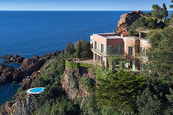 A house sits on a cliff overlooking the ocean