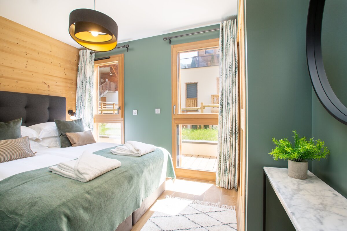 A bedroom with green walls and a large bed
