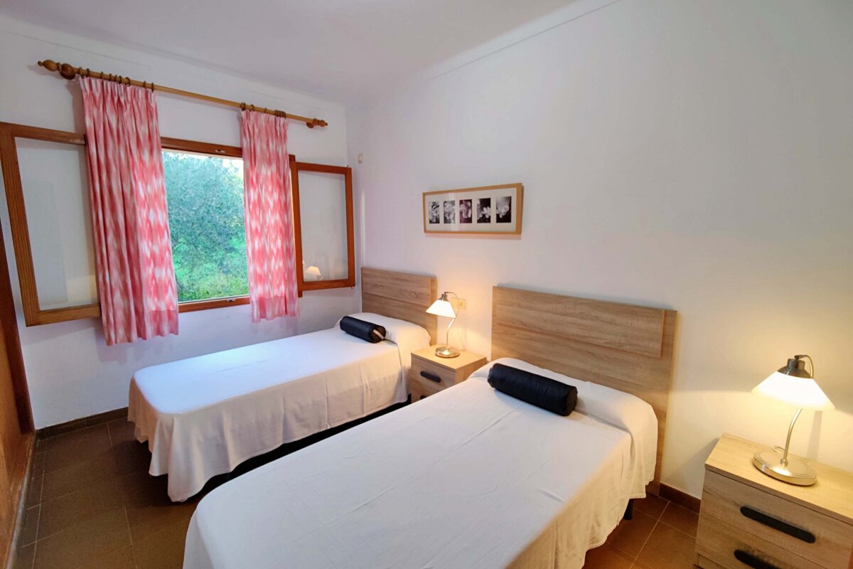 A bedroom with two beds and a picture on the wall