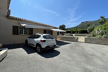 A white suv is parked in front of a house