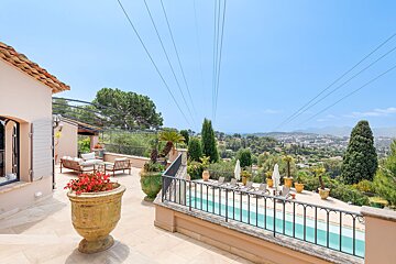 A balcony overlooking a swimming pool with a view of the mountains