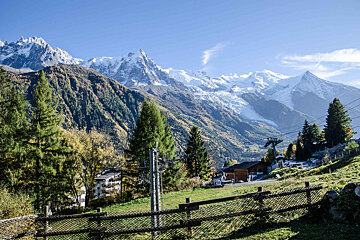 A view of a mountain range with a fence in the foreground