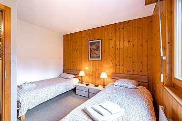 A bedroom with two beds and a picture on the wall