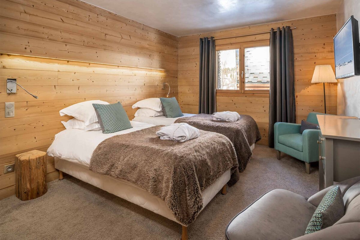A hotel room with two beds and a chair