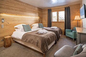 A hotel room with two beds and a chair