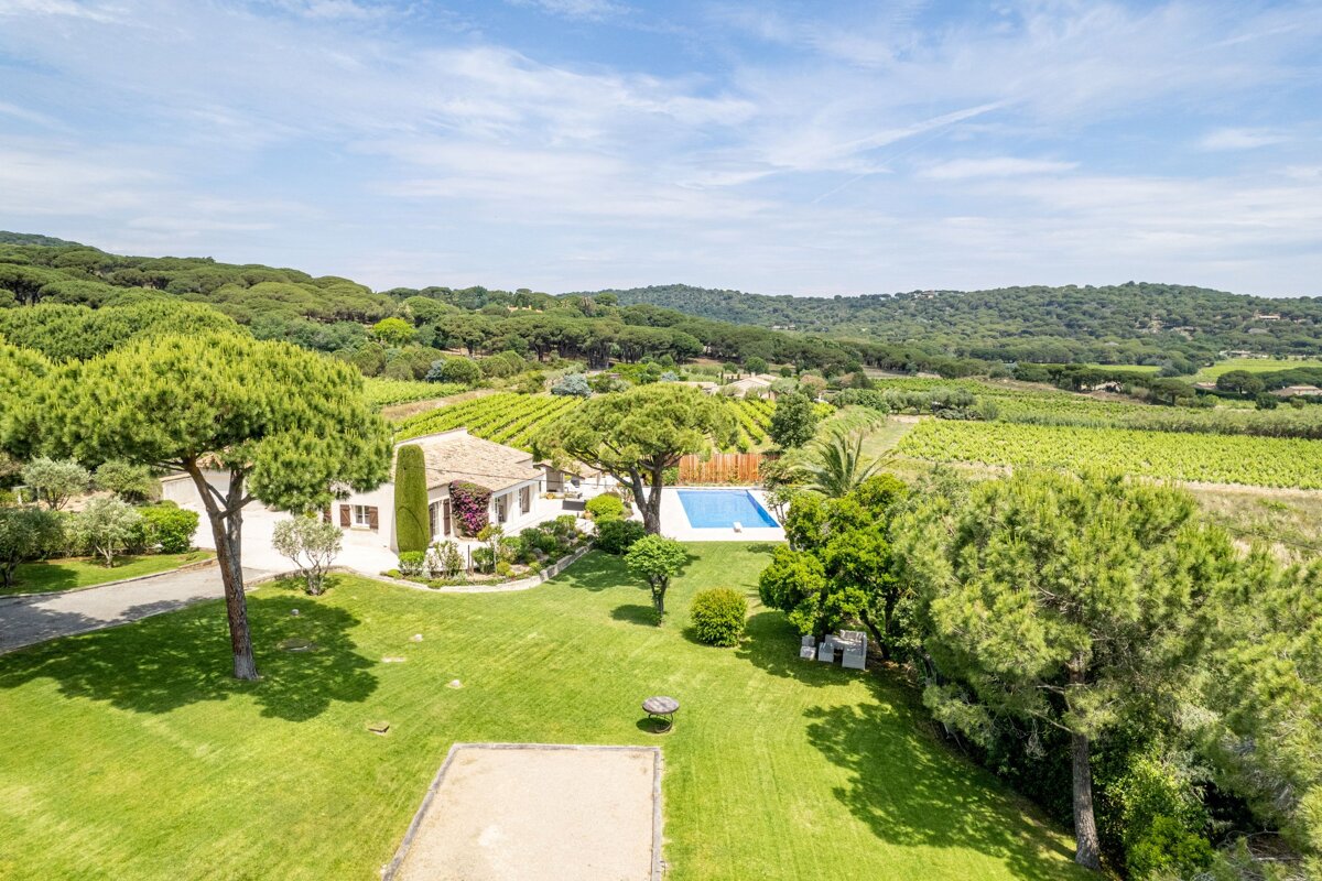 An aerial view of a house surrounded by trees and a swimming pool
