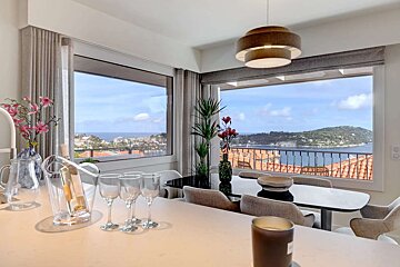 A dining room with a view of the ocean and mountains